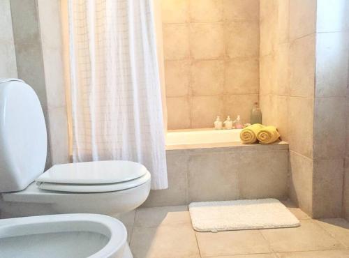 a bathroom with a white toilet and a shower at Espectacular Casa de Campo en Luján in Luján