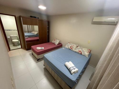 a small room with a bed and a mirror at Brisa do Mar - Zona Sul, Ilhéus in Ilhéus