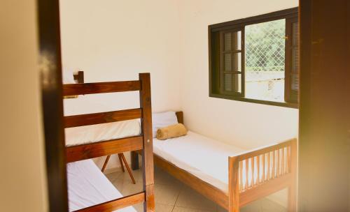 a room with two bunk beds and a window at Apto bem equipado, com 2 quartos acomoda até 6 pessoas confortavelmente in Ubatuba