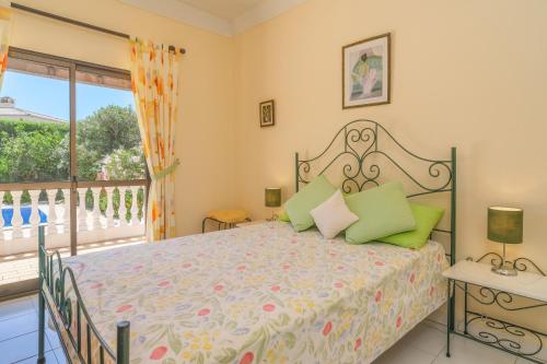 een slaapkamer met een bed en een balkon bij Vila Telo in Luz