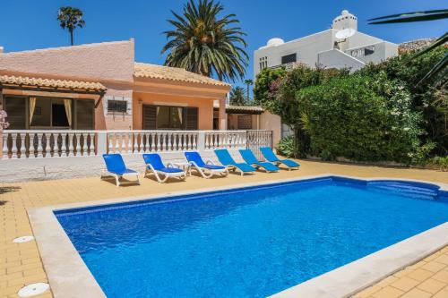 een zwembad met stoelen en een huis bij Vila Telo in Luz