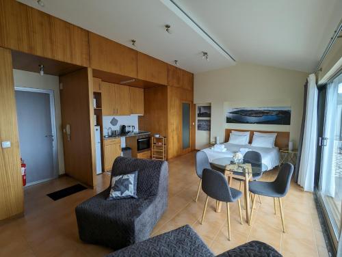 a hotel room with a bed and a table and chairs at Apartamento Avenida - AL 1798 in Horta