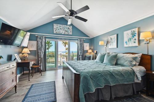 a bedroom with a bed with a ceiling fan at Sea Breeze Manor Inn in St Petersburg