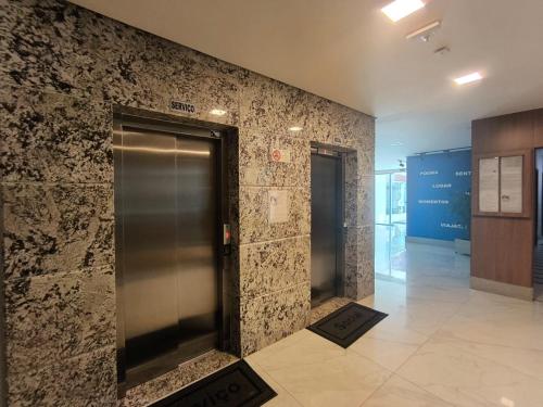 a hallway with two elevators in a building at Ivana Imoveis - Grupo de Aptos Temporada - Praia do Morro in Guarapari