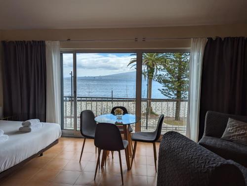 a hotel room with a bed and a table and chairs at Apartamento Avenida - AL 1798 in Horta