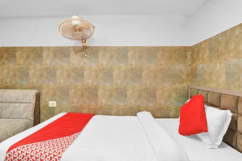 a bedroom with a bed with red and white pillows at Super Hotel O Sada Shiv Guest House in Gorakhpur