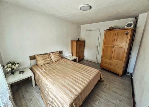 een slaapkamer met een bed en een houten kast bij Beli Dvor na Dunavu in Kovin