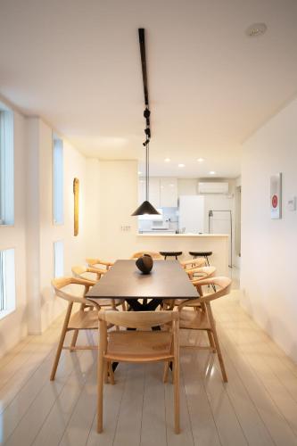a dining room with a table and wooden chairs at Ashina Bayfront Villa in Yokosuka