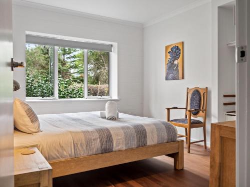 Un dormitorio con una cama y una ventana y una silla. en Pedaler's Rest - Margaret River NEW, en Margaret River Town