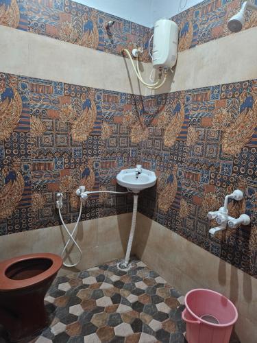 哥印拜陀的住宿－Spandha3 - 2Bedroom house in Coimbatore，一间带水槽和卫生间的浴室以及马赛克墙