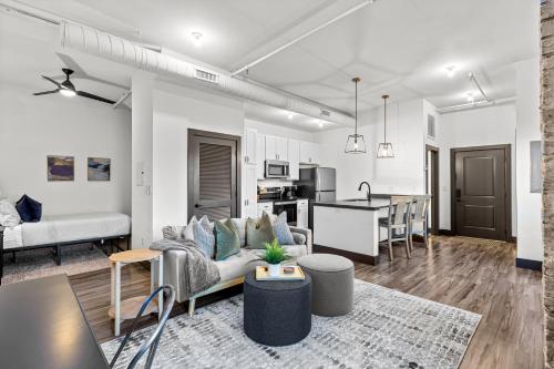 a living room with a couch and a kitchen at Brick & Bed Riverfront Lofts, PC 203 in Saint Louis
