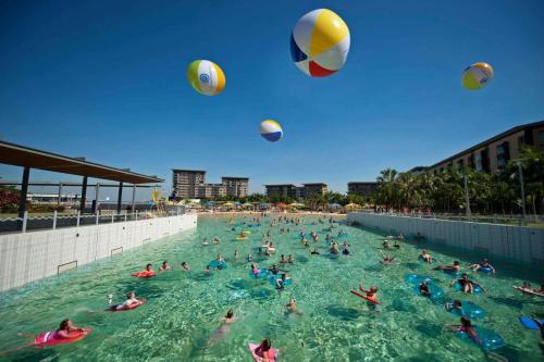 a group of people playing with volley balls in a swimming pool at Oceania at Darwin Waterfront in Darwin