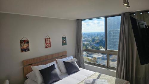 a bedroom with a bed and a large window at Best Apartment Rental Estación Central in Santiago