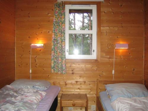 2 camas en una cabaña de madera con ventana en Fjordhytte-38 bei Rosendal am Hardangerfjord, en Rosendal