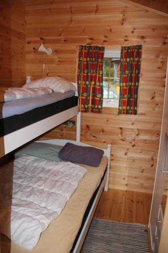 two bunk beds in a room with wooden walls at Fjordhytte-39 am Hardangerfjord, Motorboot mietbar in Rosendal