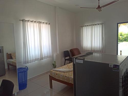 een woonkamer met een bank en een tafel en stoelen bij Bethesda Inn in Cochin