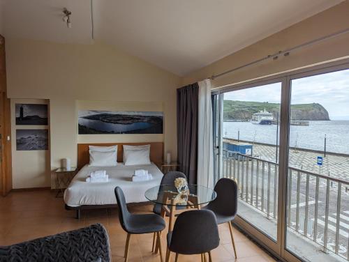a hotel room with a bed and a balcony at Apartamento Avenida - AL 1798 in Horta