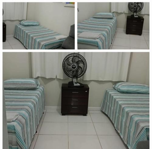 a room with two beds and a fan on a dresser at Flat Sandra in Teixeira de Freitas