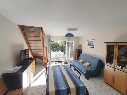 ein Wohnzimmer mit einem blauen Sofa und einer Treppe in der Unterkunft Maison Sarzeau, 3 pièces, 4 personnes - FR-1-639-19 in Sarzeau