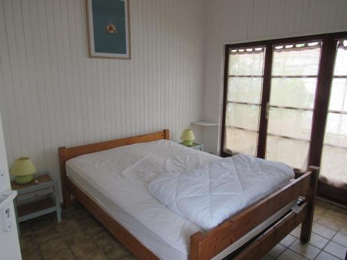 1 Schlafzimmer mit einem Bett mit weißer Bettwäsche und 2 Fenstern in der Unterkunft Maison La Faute-sur-Mer, 6 pièces, 10 personnes - FR-1-194-248 in La Faute-sur-Mer
