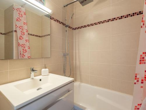 een badkamer met een wastafel, een spiegel en een bad bij Studio Arcachon, 1 pièce, 3 personnes - FR-1-319-547 in Arcachon