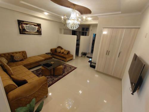 a living room with couches and a flat screen tv at Bhurban Luxury Suites in Murree