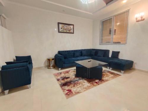 a living room with a blue couch and a table at Bhurban Luxury Suites in Murree