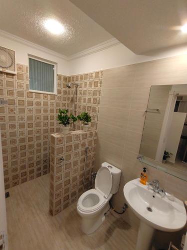 a bathroom with a toilet and a sink at Bhurban Luxury Suites in Murree