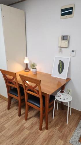 a wooden table with two chairs and a laptop on it at Kiman09 in Seoul