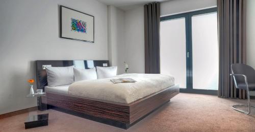 a bedroom with a bed and a chair in it at Hotel im Wigbold in Ochtrup