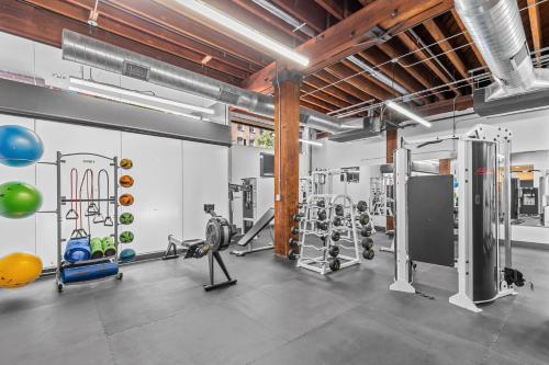 a gym with treadmills and machines in a room at Brick & Bed Riverfront Lofts, PC 102 in Saint Louis