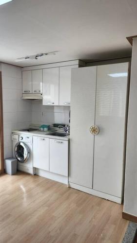 a kitchen with white cabinets and a washing machine at Kiman09 in Seoul