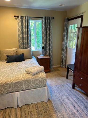 a bedroom with a bed and a dresser and windows at Ocean views, indoor and outdoor brilliance! in Haleiwa