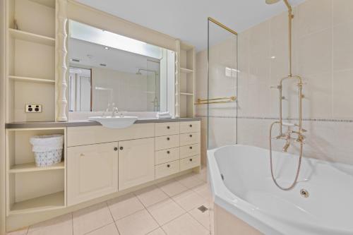 a bathroom with a tub and a sink at Burgess @ Kings Beach Apartments in Caloundra