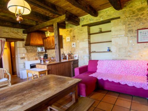 un salon avec un canapé rose et une table dans l'établissement Maison avec jardin, Wifi, animaux acceptés près de Sarlat - FR-1-616-45, à Bardenac