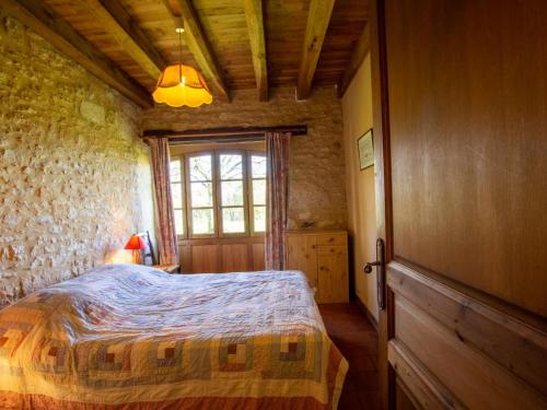 une chambre avec un lit dans une pièce avec une fenêtre dans l'établissement Maison avec jardin, Wifi, animaux acceptés près de Sarlat - FR-1-616-45, à Bardenac