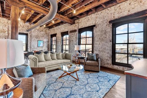 a living room with a couch and a table at Brick & Bed, Riverfront Lofts, PC 206 in Saint Louis