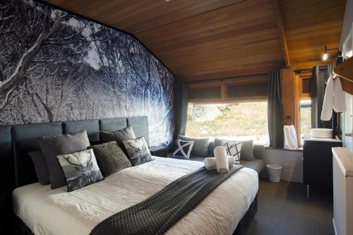 a bedroom with a large bed with a blue wall at Barrakee Ski Lodge in Perisher Valley