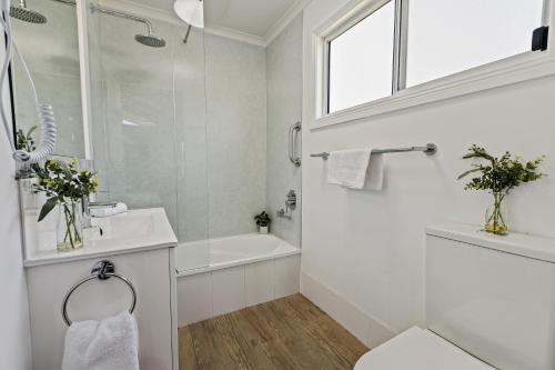 a white bathroom with a sink and a shower at Tasman Holiday Parks - Merimbula in Merimbula