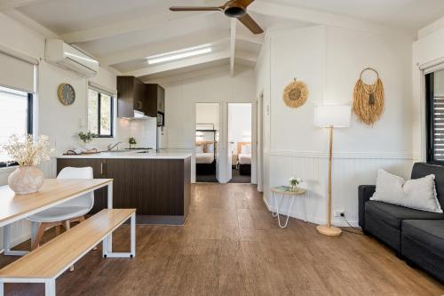 a living room and kitchen with a couch and a table at Tasman Holiday Parks - Merimbula in Merimbula