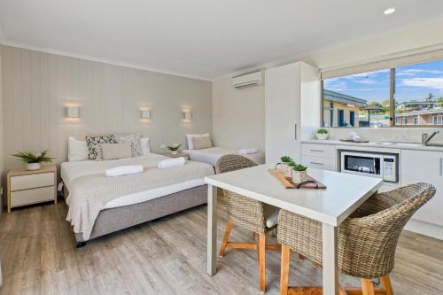 um quarto com uma cama e uma mesa com cadeiras em Tasman Holiday Parks - Merimbula em Merimbula