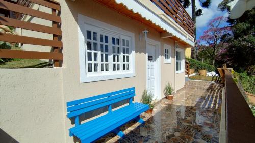 un banc bleu assis à l'extérieur d'une maison dans l'établissement Mouton Blanc Campos do Jordão, à Campos do Jordão