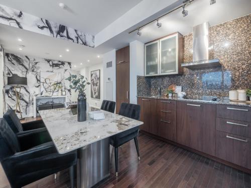a kitchen with a marble counter top and wooden cabinets at Luxury 2Br Condo Entertainment District Downtown CN Tower View Balcony Pool & Hot Tub in Toronto