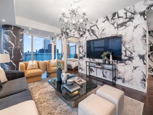 a living room with a couch and a tv at Luxury 2Br Condo Entertainment District Downtown CN Tower View Balcony Pool & Hot Tub in Toronto