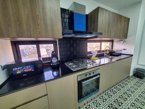 a kitchen with a stove and a counter top at Apartamento Frente a Parque en Urb. California in Víctor Larco Herrera