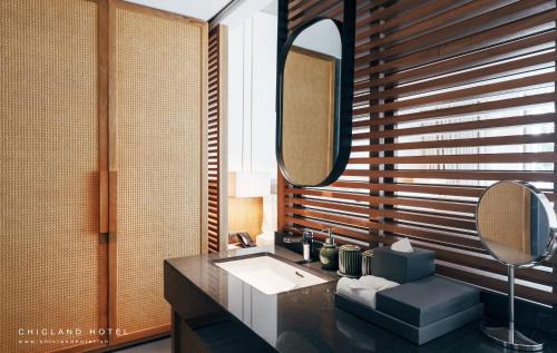 a bathroom with a sink and a mirror at Chicland Boutique Danang Beach Hotel in Da Nang