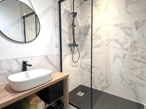 une salle de bain avec une douche avec un lavabo et un miroir dans l'établissement Appartement rénové avec terrasse au Pouliguen, proche plage, port et commerces - FR-1-392-235, au Pouliguen