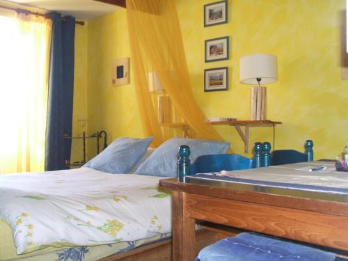 ein Schlafzimmer mit einem Bett und einer gelben Wand in der Unterkunft Mas des Retrouvailles in Châteaurenard
