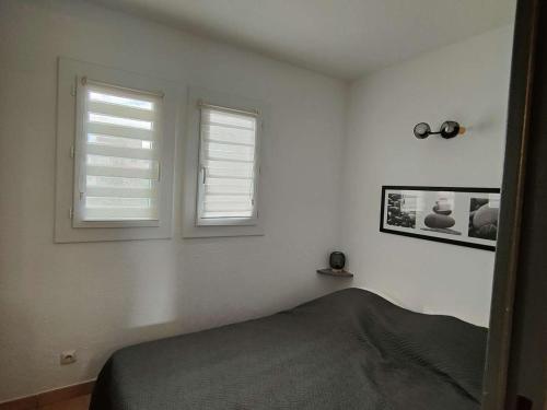 - une chambre avec deux fenêtres et un lit dans l'établissement T2 Cabine avec Terrasse et Parking - Le Barcarès - FR-1-195-109, au Barcarès