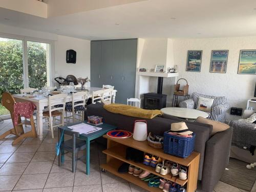 un salon avec un canapé et une table dans l'établissement Maison Enfants Bienvenue, à 100m Plage, Jardin, WiFi, Parking, Terrasse & Équipements Complets - FR-1-465-113, à Merville-Franceville-Plage